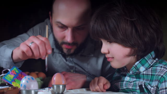 4K-tiro-familiar-del-niño-con-los-huevos-de-Pascua-pintura-papá