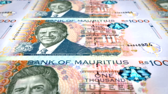 Banknotes-of-one-thousand-rupees-of-the-bank-of-the-Mauritius-Islands-rolling-on-screen,-coins-of-the-world,-cash-money,-loop