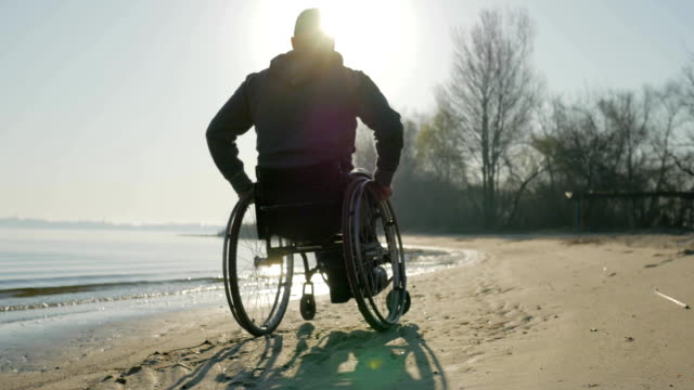 Ungültige-Fahrten-entlang-Strand-in-Rollstuhl,-Behinderten-Vertrauen-in-Zukunft-Mann