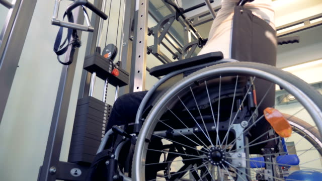 Carga-de-potencia-para-el-débil-del-hombre-discapacitado-detrás-de-los-músculos-en-una-silla-de-ruedas.