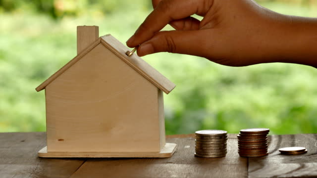 Die-Frauen-insert-Coin-in-einem-Haus-mit-Natur-Hintergrund