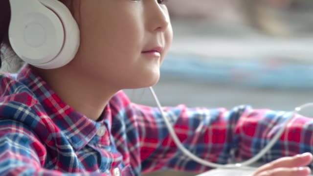 Kleine-Asiatin-in-Kopfhörer-Smartphone-Musik-weiter