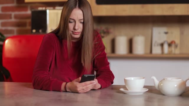 Junge-Frau-im-Internet-surfen,-Überprüfung-von-Neuigkeiten-in-sozialen-Netzwerken-mit-Smartphone-in-der-Küche.