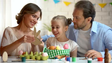 Family-admiring-wooden-toy-in-shape-of-bunny,-Easter-symbol,-handmade-decoration