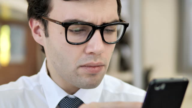 Close-Up-of-Young-Businessman-Scrolling-Smartphone