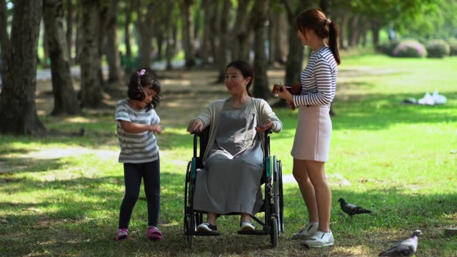 Cheerful-mother-with-two-cute-daughter-in-park