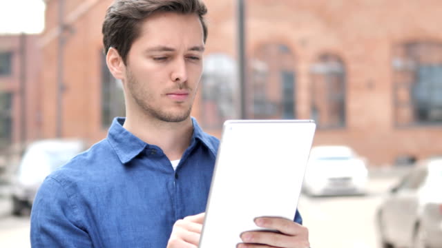 Outdoor-Portrait-of-Young-Man-Using-Tablet