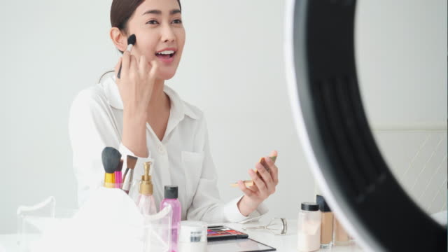 Asiatische-schöne-Frau-leben-Lehre-über-Schönheit-Make-up-online.-Frau-posiert-vor-der-Kamera-im-Studio.-Konzept-von-Schönheit,-Mode-und-Kosmetik.