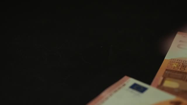 Banknotes-10-euro-slowly-falling-on-the-black-table.-Closeup.-Slow-motion
