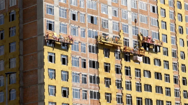 Polipastos-de-construcción-con-trabajadores-en-la-fachada-de-la-casa.