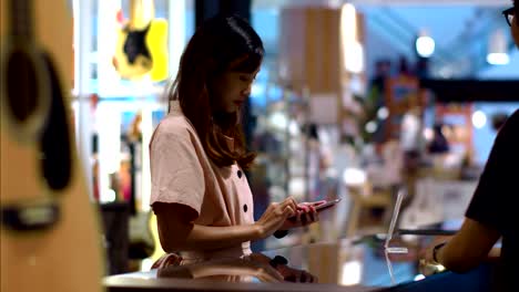Mujer-joven-pagando-escaneando-código-QR-con-teléfono-inteligente