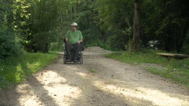 4k-Auflösung-Porträtvideo-eines-behinderten-Mannes-in-einem-elektrischen-Rollstuhl-in-der-Natur