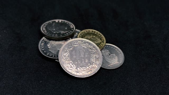 Monedas-Frank-suizos-girando-sobre-negro---CHF
