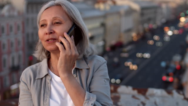 Mujer-envejecida-hablando-en-el-teléfono-celular-en-el-techo