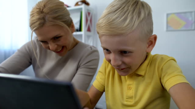 Cheerful-mother-and-son-playing-game-on-tablet,-trustful-relationships,-pastime