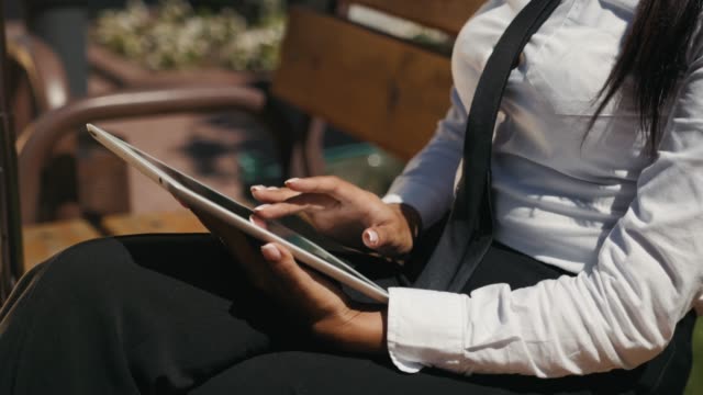 Mujer-leyendo-Tablet-Tablet-Device.-Una-joven-adulta-española-latina-compra-online-reservando-al-aire-libre-en-la-calle,-terminal-del-aeropuerto