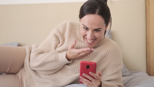 Surprise-woman-using-mobile-phone-in-bed