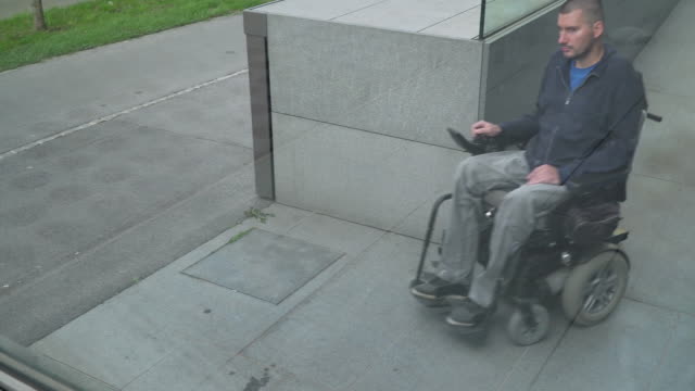 4k-resolution-follow-of-a-man-on-electric-wheelchair-using-a-ramp.-Accessibility-concept