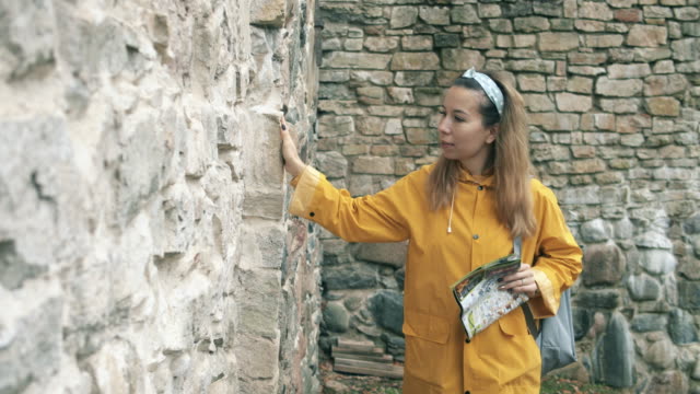 Una-turista-está-tocando-una-antigua-pared-de-ladrillo