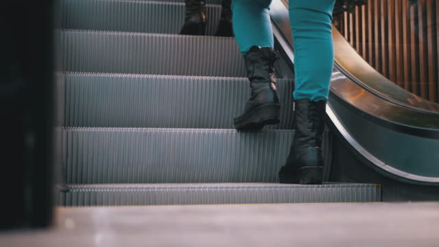 Legs-of-People-Moving-on-an-Escalator-Lift-in-the-Mall.-Shopper's-Feet-on-Escalator-in-Shopping-Center