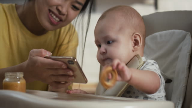 Mutter-zeigt-Smartphone-zu-Baby