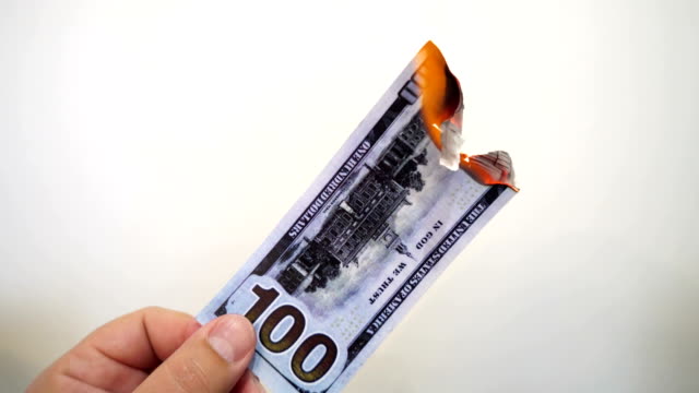Hand-mit-einer-brennenden-hundert-Dollar-banknote