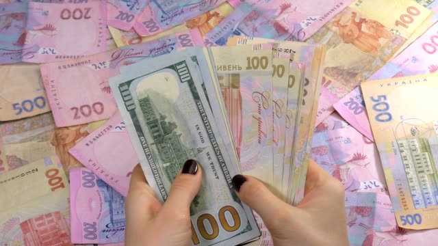 Businessman's-hands-counting-money-dollar-and-hryvnia.-Counting-Ukrainian-money.