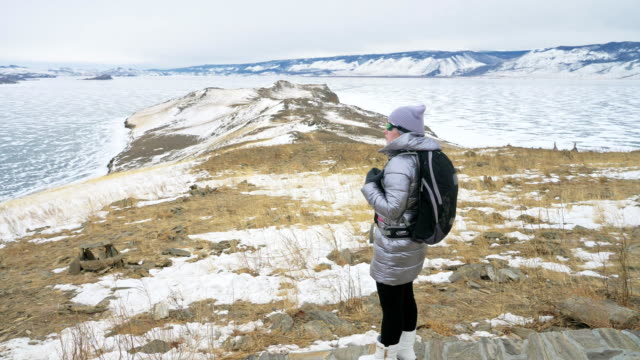 Viaje-de-la-mujer-en-el-hielo-del-lago-Baikal.-Cierre-único-budista-stupa-burkhan-monumento-símbolo-místico-isla-ritual-histórico-Ogoi-paisaje-montañas-chamánica-adoración.-Viaje-a-la-isla-de-invierno.