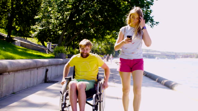 Young-disable-man-on-a-walk-near-the-river-with-his-wife