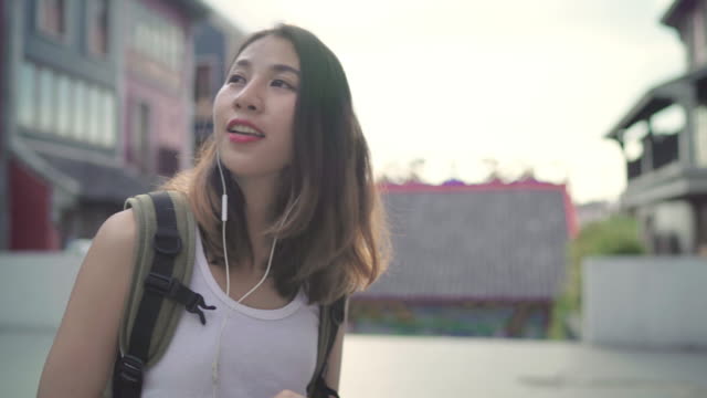 Asiatischen-Backpacker-Blogger-Frau-mit-Smartphone-für-Chat,-social-Media-Check-und-hören-Sie-Musik-während-der-Fahrt-in-Chinatown-in-Peking,-China.-Lebensstil-Rucksack-Tourist-Reisen-Urlaub-Konzept.