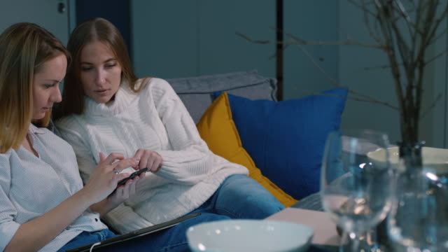 Joven-alegre-mujer-sentada-en-sofá-en-mesa-y-uso-de-smartphone