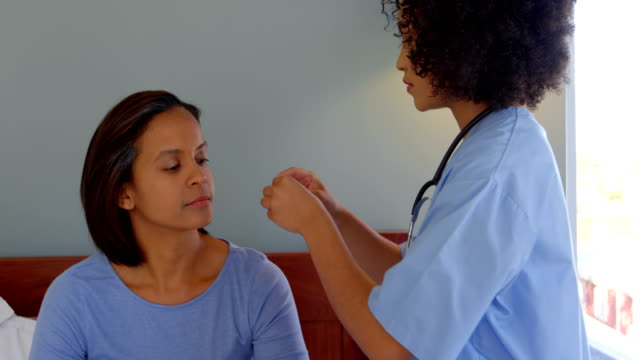 Doctora-de-raza-mixta-insertar-una-prótesis-de-oído-de-la-máquina-en-el-oído-de-la-mujer-en-casa-4k