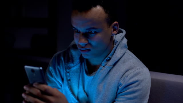 Black-teenager-surfing-net-in-darkness,-threats-from-internet,-gadget-addiction