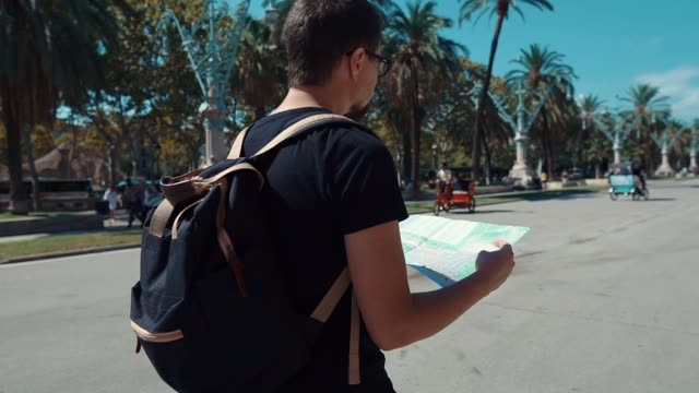Männlicher-Tourist-liest-Stadtplaner-zu-Fuß-in-der-Nähe-des-Arc-de-Triomphe-in-Barcelona