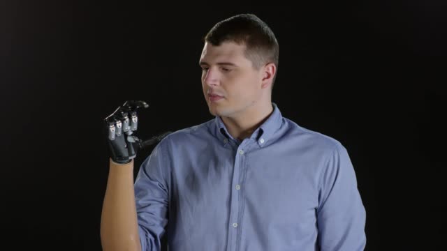 Behinderter-Mann-mit-Prothesen-Arm-auf-schwarzem-Hintergrund