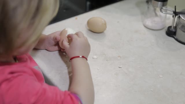 Nahaufnahme-eines-kleinen-Mädchens-reinigt-die-Schale-mit-einem-gekochten-Hühnerei