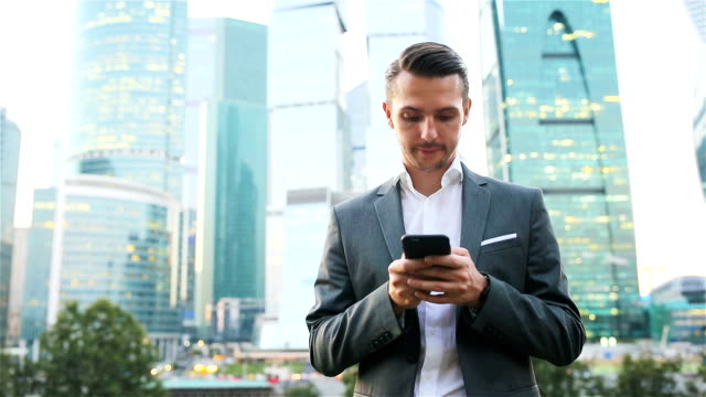 Junger-kaukasischer-Mann-hält-Smartphone-für-Geschäftsarbeit.