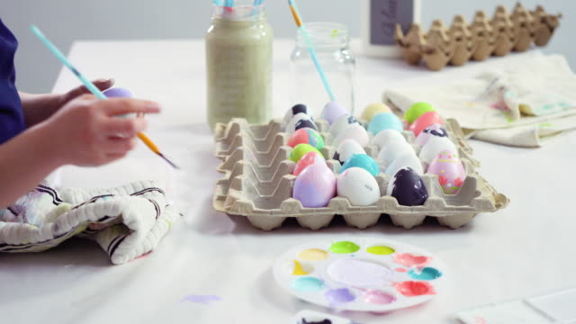 Little-girl-painting-craft-Easter-eggs-with-acrylic-paint.