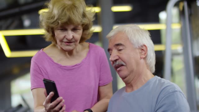 Personas-mayores-que-usan-Smartphone-para-hacer-ejercicio-en-el-gimnasio