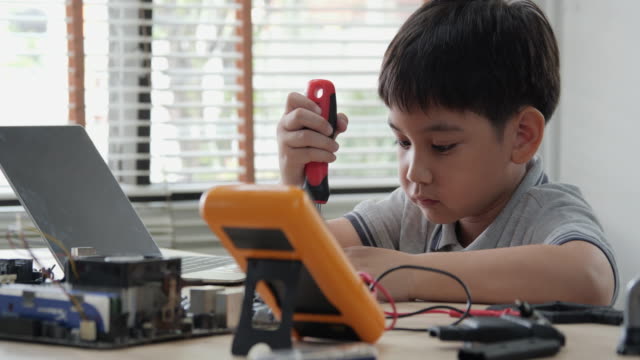 Boy-try-to-fixing-computer-board-in-school-science-club.-Project-for-engineering-club-in-school.-People-with-technology-concept.
