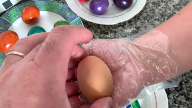 Una-mujer-con-guantes-pinta-huevos