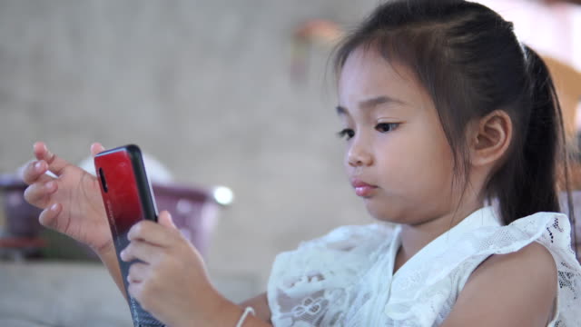 Asia-girl-playing-game-online-on-mobile-phone