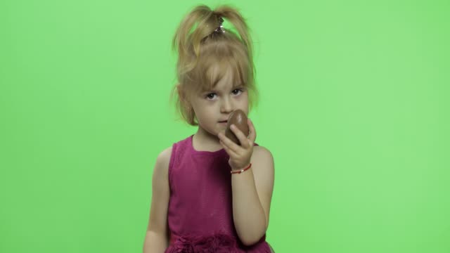 Chica-con-vestido-morado-con-huevo-de-chocolate.-Feliz-niño-de-cuatro-años.-Chroma-Key