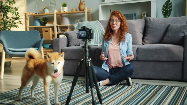 Slow-motion-of-joyful-blogger-dog-owner-recording-video-using-modern-camera