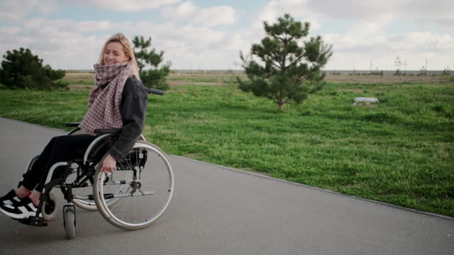 Fröhliche-behinderte-Frau-im-Rollstuhl-genießt-den-Tag