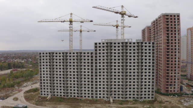4k-Aerial-view-big-construction-cranes-and-unfinished-houses