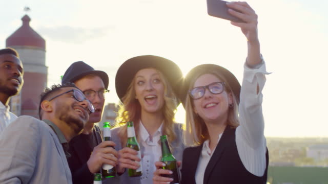 Joyous-Freunde-machen-Selfie-mit-Smartphone-auf-der-Rooftop-Party