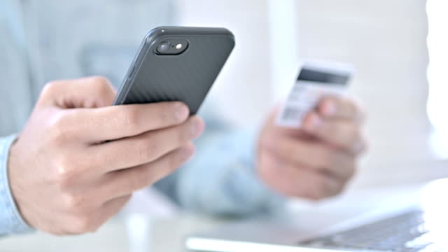 Nahaufnahme-der-Hände-mit-Kreditkarte-auf-dem-Smartphone