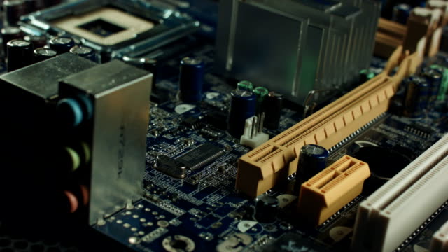 computer-motherboard-isolated-in-white-background-with-a-person-hand-placing-an-equipment-into-the-motherboard