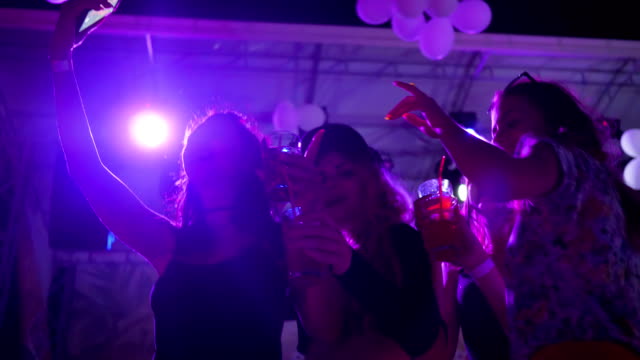 selbst-Foto-mit-hellen-Drink-im-Nachtclub,-sexy-Frauen,-die-bei-Nacht-Party-mit-Alkohol-tanzen,-tanzen-Mädchen-mit-Getränk